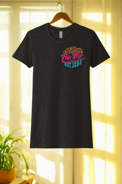 Black t-shirt with colorful text design hanging on a wooden hanger against a bright window background.