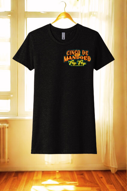 Black t-shirt with yellow text on a hanger in a room with curtains and wooden floor.