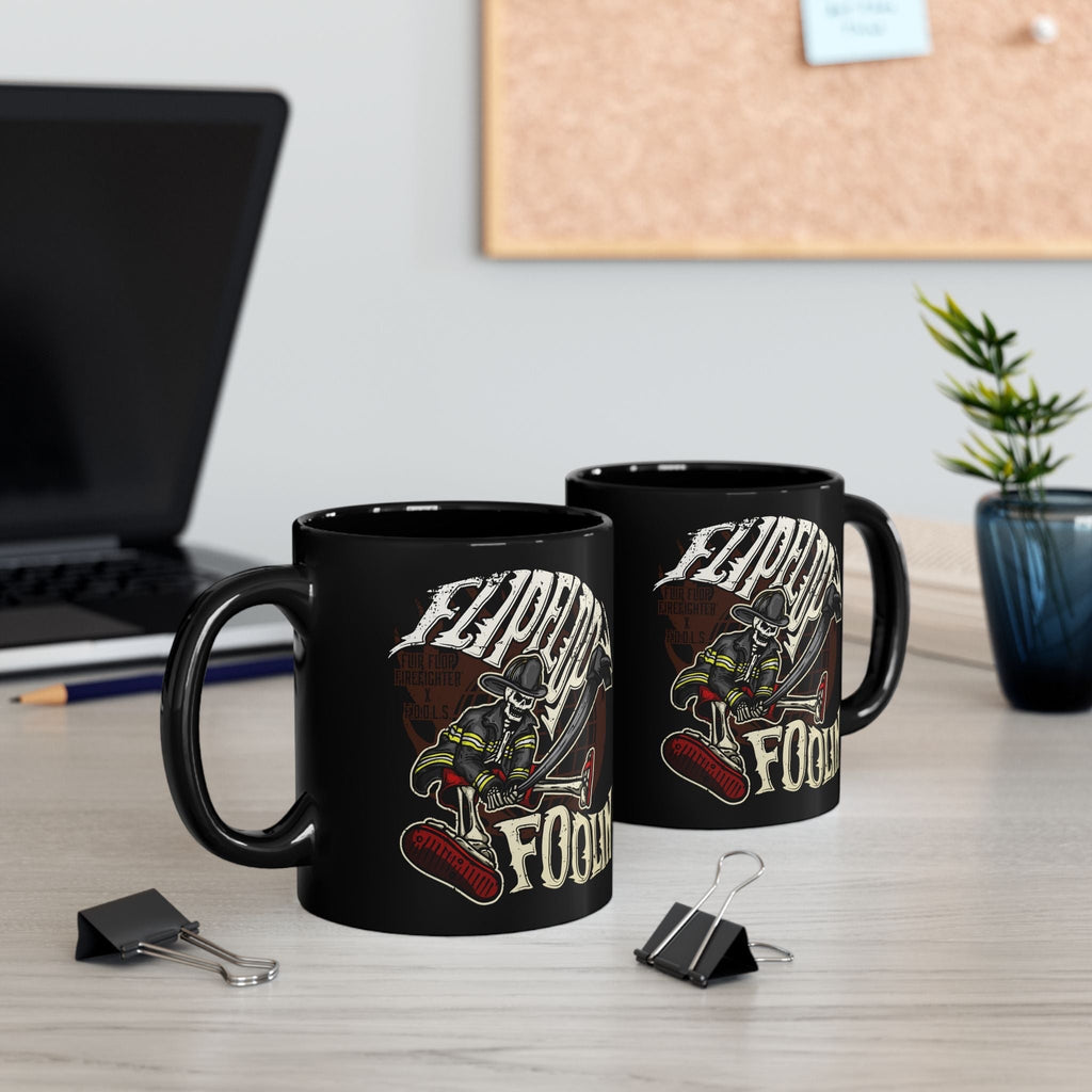 Flip Flop Firefighter glossy black ceramic coffee mug featuring a skeleton firefighter graphic on a desk.