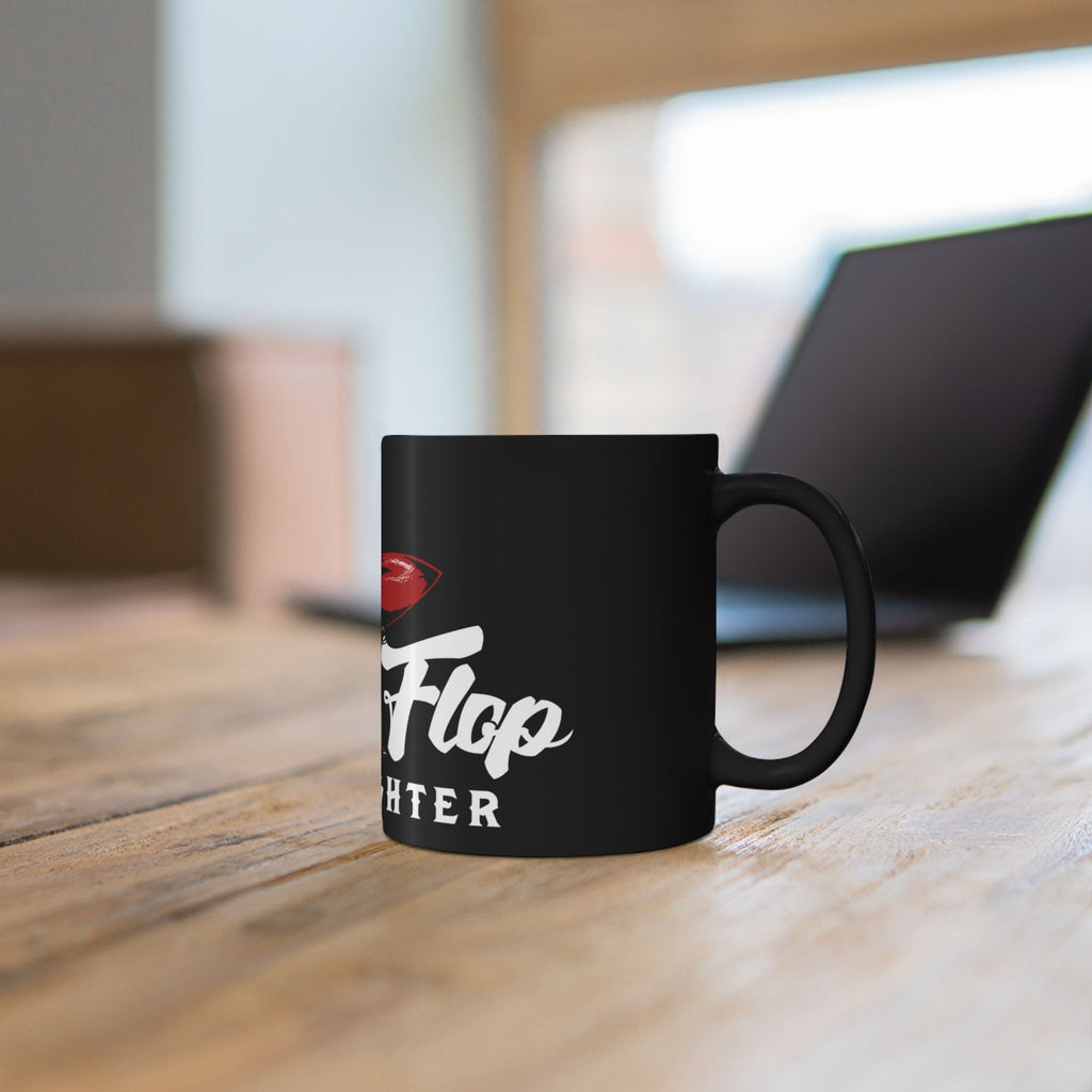 Flip Flop Firefighter glossy black ceramic coffee mug with white graphic text on a wooden desk.