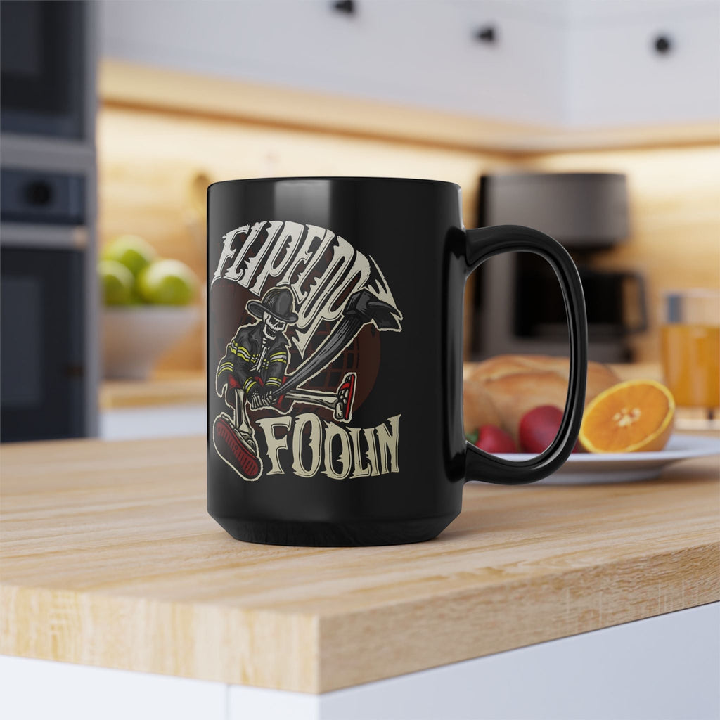 Flip Flop Firefighter glossy black ceramic coffee mug with a skeleton firefighter graphic on a kitchen counter.