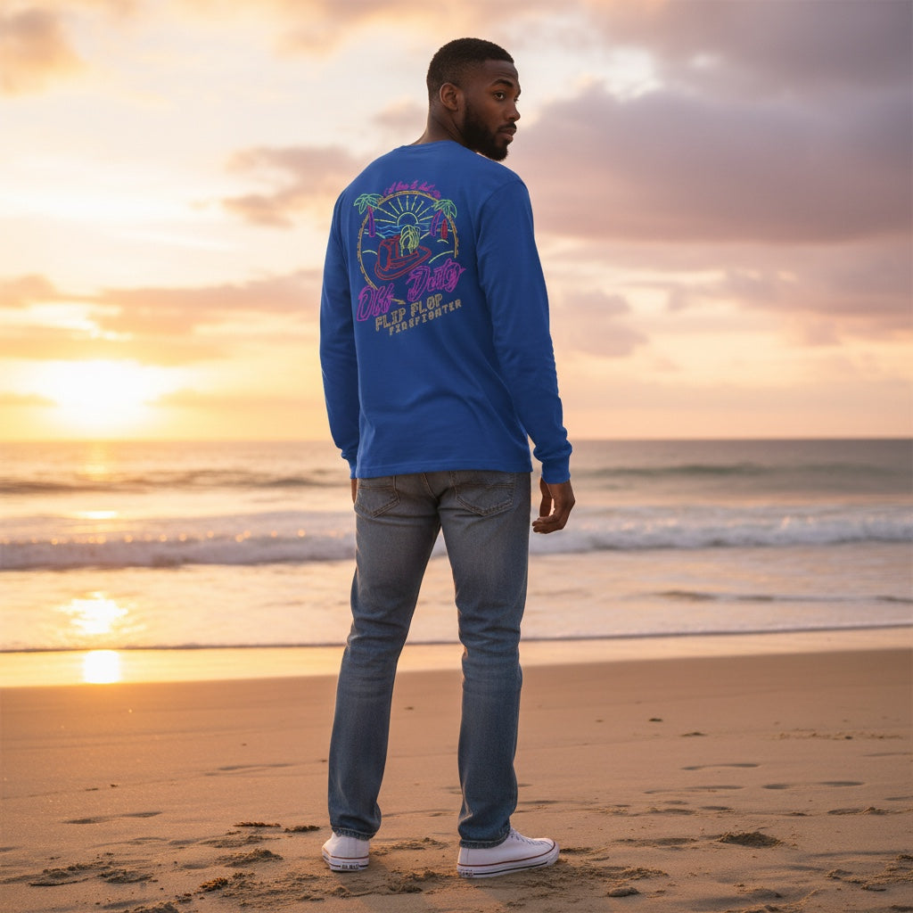 Flip Flop Firefighter blue long-sleeve shirt with neon graphic on back, worn by a man on a beach at sunset.
