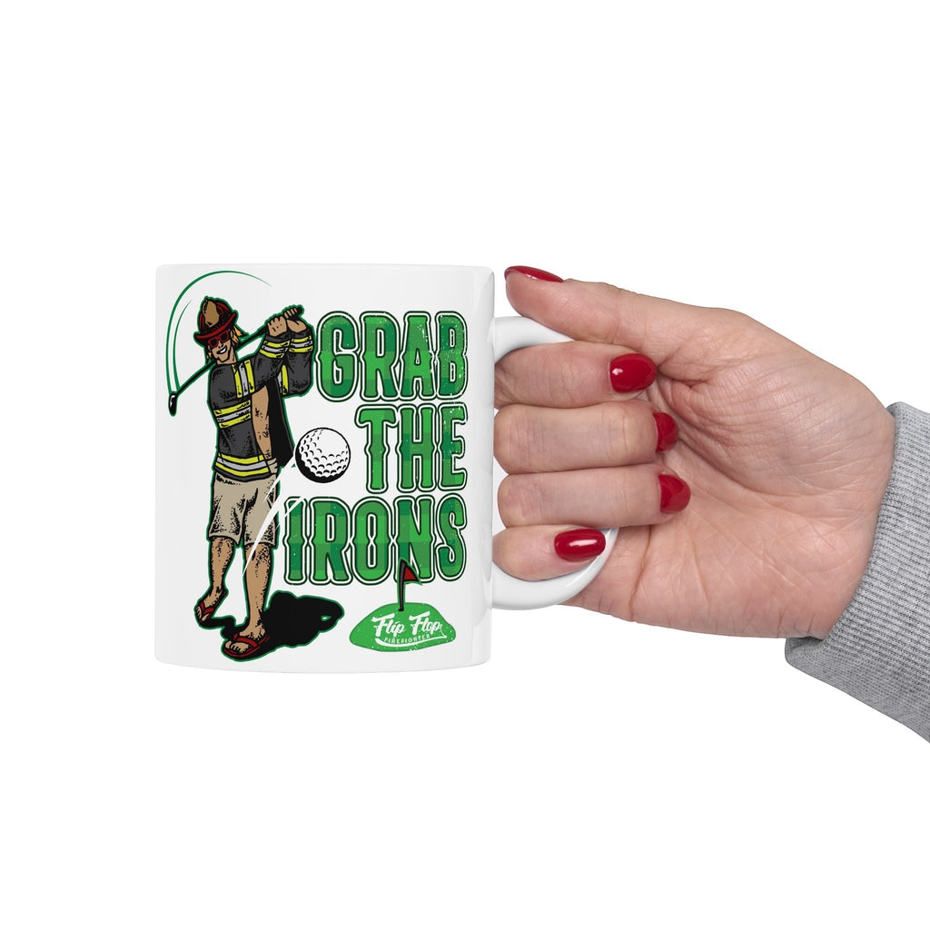 Flip Flop Firefighter white ceramic coffee mug featuring a firefighter golfing graphic and Grab The Irons text