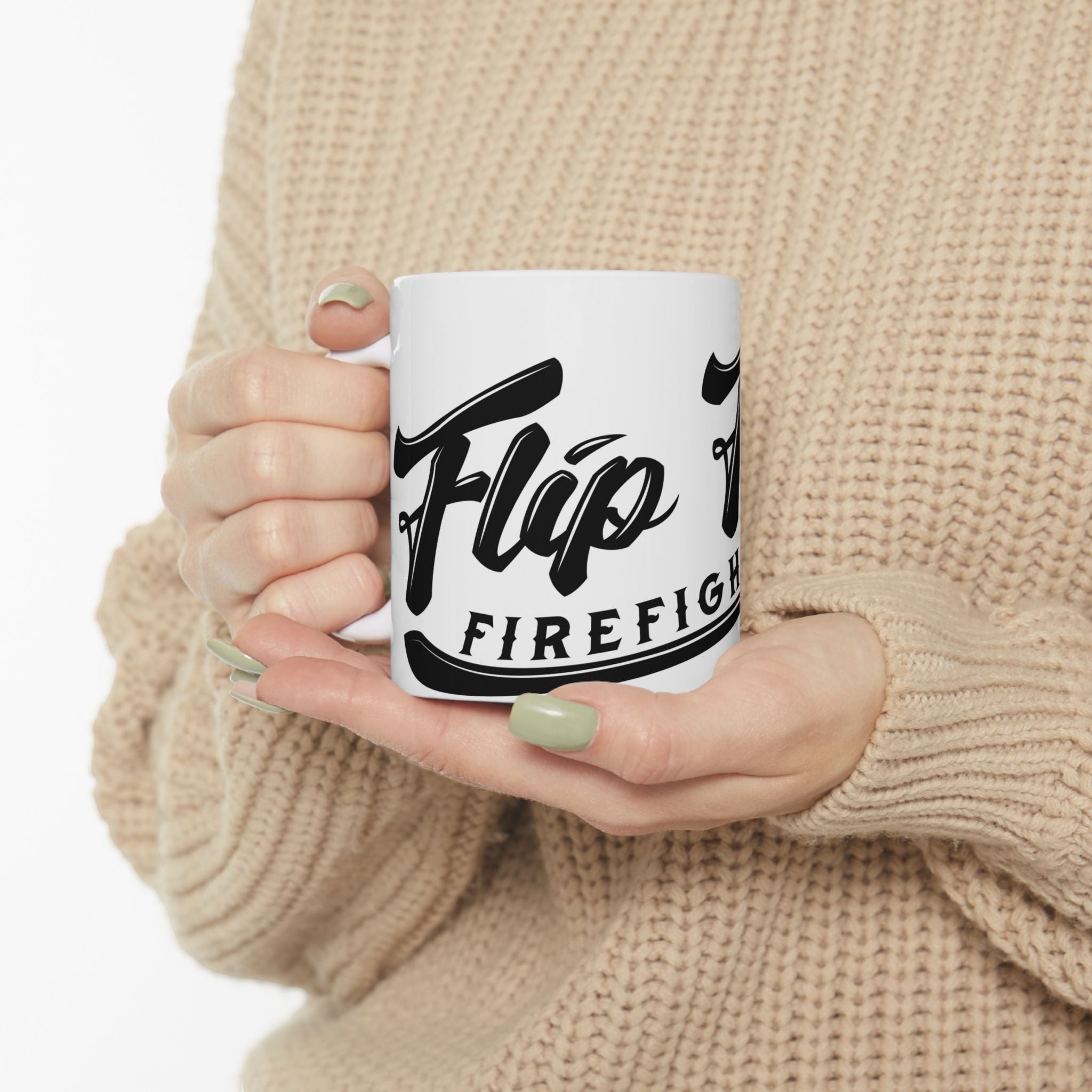 Flip Flop Firefighter white ceramic coffee mug with black logo held by a person in a beige knit sweater